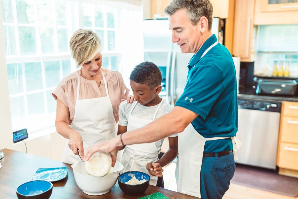 A family of three enjoys cooking together at home, fostering bonding and teamwork.